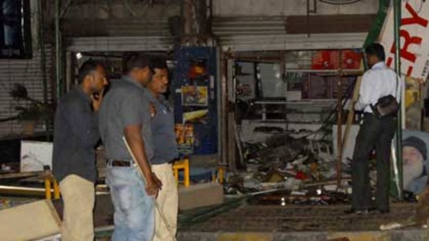 Police gather at the site where a bomb ripped through a packed restaurant in the Indian city of Pune, killing at least eight people including four foreign women.
