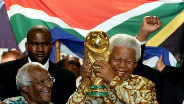 Nelson Mandela holding the soccer World cup beside Capetown Archbishop Desmond Tutu.