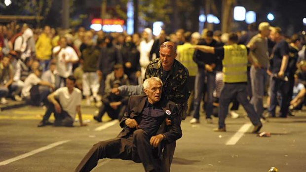 Clashes with police ... a man helps a supporter during a protest by the Serbian Radical Party against the arrest of general Ratko Mladic in Belgrade.