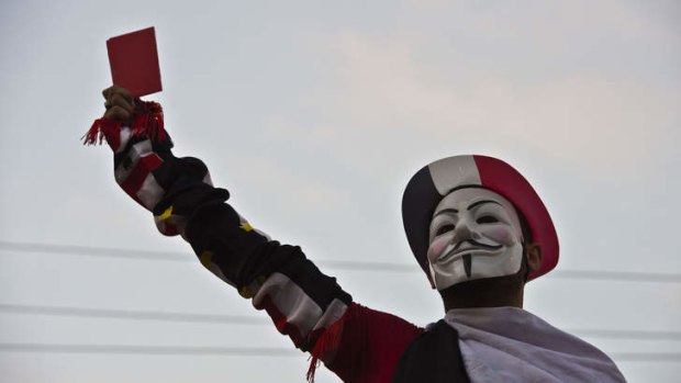 Shown the red card: A protester makes his point outside the presidential palace in Cairo.