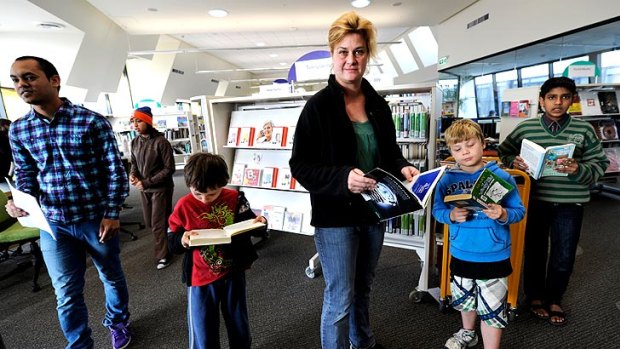 Jack Attard, Sally Attard and Josh Maiden enjoy books at the Altona North Library. Councils say the cuts could affect staffing and opening hours.