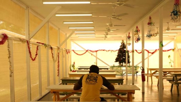 A man sits inside the Nauru off shore processing centre in 2007 ... The opposition immigration spokesman, Scott Morrison, has claimed Nauru can be reopened and run for a third of  the Immigration Department’s $2 billion estimate.