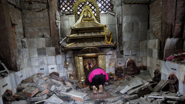 A Hindu Nepalese woman offers prayers at Indrayani temple, which was damaged in the earthquake.