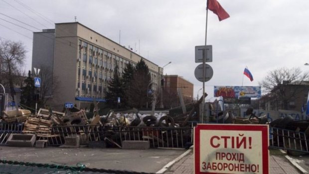 Barricades and Soviet era red and Russian national flags at an entrance to the security service building in Luhansk.