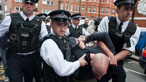 A supporter of WikiLeaks founder Julian Assange is arrested outside the Ecuadorian Embassy in London.