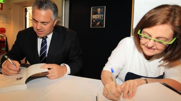 Sign of approval: Joe Hockey and writer Madonna King autograph the tome.