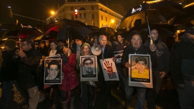 Relatives of Israelis killed in attacks by Palestinian militants hold photos of victims during a demonstration against the release of 26 long-serving Palestinian prisoners in Jerusalem.