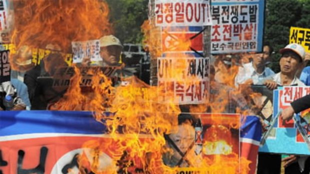 South Korean protesters burn a North Korea flag and portraits of leader Kim Jong-Il during a protest over the latest nuclear test.