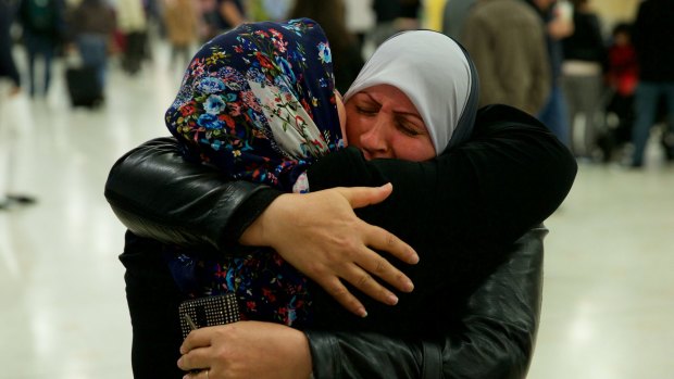 For the first time in nearly a decade, Dhekra Mohsin, at right, hugs her daughter Zahra Aobadah, who has been in a Turkish refugee camp with her husband and four daughters.