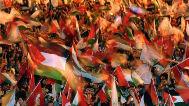 People wave Turkish and Palestinian flags during a rally to mark the first anniversary of the violence that occurred on the passenger ship <em>MV Mavi Marmara</em> in May 2010.