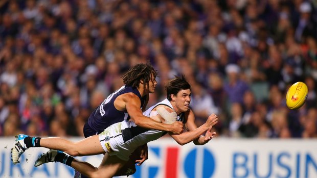 PERTH, AUSTRALIA - SEPTEMBER 13:  Angus Monfries of the Power gets his handball away while being tackled by Tendai Mzungu of the Dockers during the AFL 1st Semi Final match between the Fremantle Dockers and the Port Adelaide Power at Patersons Stadium on September 13, 2014 in Perth, Australia.  (Photo by Paul Kane/Getty Images)