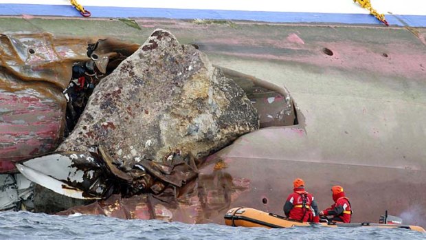 A rock emerges from the side of the luxury cruise ship.