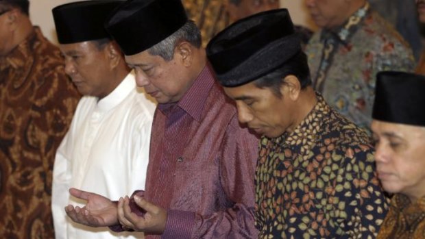 Prabowo Subianto, President Susilo Bambang Yudhoyono and Joko Widodo praying at the State Palace in Jakarta.