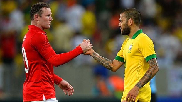 Wayne Rooney of England shakes hands with Daniel Alves of Brazil after their team's drew.