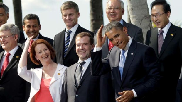 Camera ready ... Barack Obama jokingly mimics Julia Gillard’s hair-grooming gesture at the APEC leaders meeting photo call on Sunday.