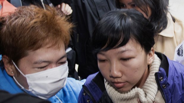 'I was tortured' ... Former Indonesian domestic helper Erwiana Sulistyaningsih (right) is helped to enter a district court in Hong Kong.