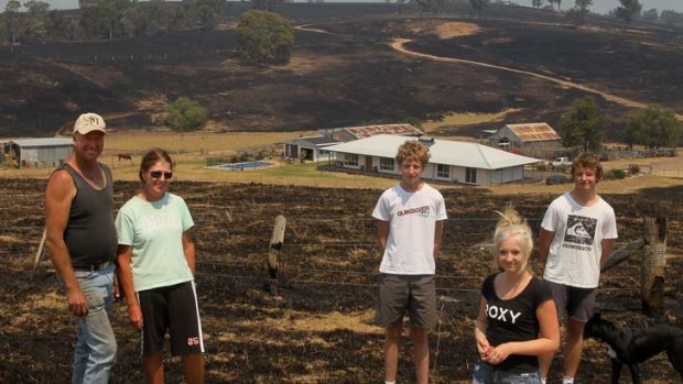 Relief: Glenn and Sharon Cumming and children (from left) Nathan, Bec and Steve in front of their home, which they saved after a 12-hour battle with the fire.