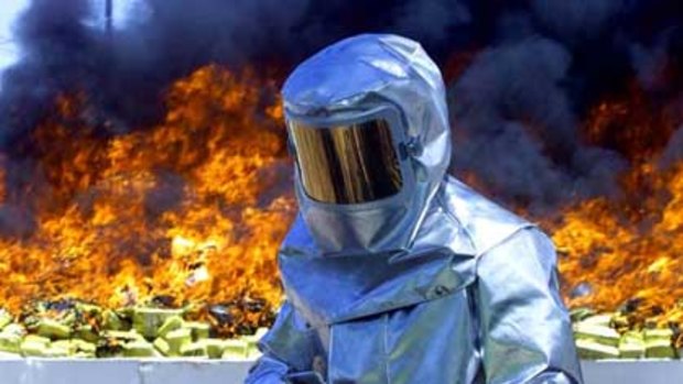 A Mexican federal policeman guards the burning of three and a half tonnes of cocaine.