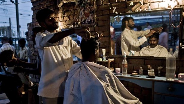 A customer at a street barber in New Delhi.
