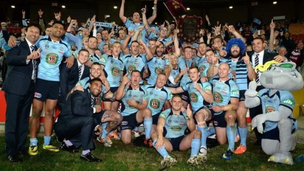 Premium on success: The victorious NSW squad celebrate with the Origin shield after the final match of the series in Brisbane on Wednesday. 