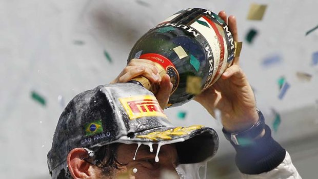 Winner ... Mark Webber is covered in champagne.