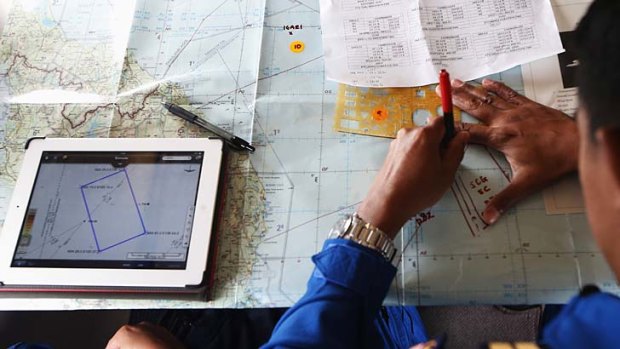 Search delay: A Malaysian Maritime Enforcement Agency pilot studies a map onboard a Japan Coast Guard aircraft, customised for search and rescue operations.