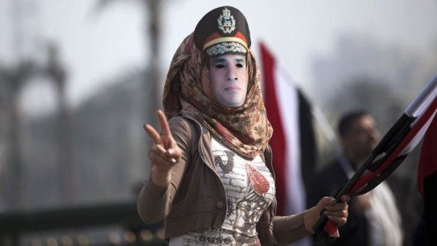 Rally: A woman wears a mask depicting Defence Minister General Abdel Fattah al-Sisi.