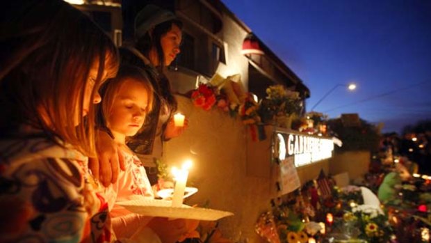 Deep impact ... children gather for a candlelight vigil outside the office of shooting victim Gabrielle Giffords in Tucson on Sunday night.