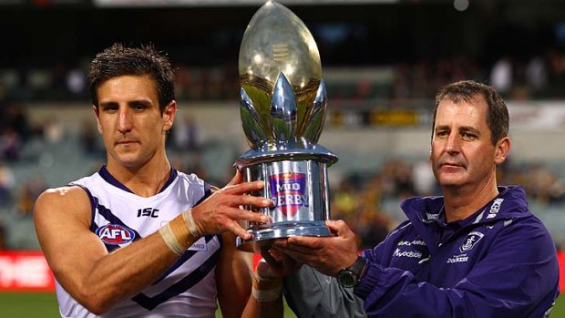 Matthew Pavlich and Ross Lyon hold the trophy Fremantle received for defeating West Coast on Sunday.