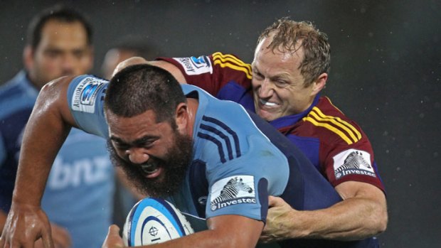 Charlie Faumuina of the Blues is tackled by the Highlanders' Tony Brown.