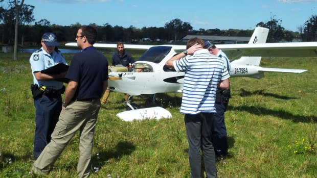 Police and witnesses at a Victoria Point paddock where a light plane made an emergency landing this morning