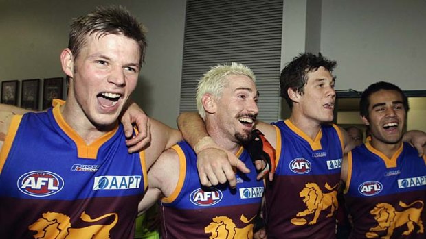 Glory days: Jason Akermanis (second from left) and Lions teammates celebrate a victory at the Gabba in 2006.
