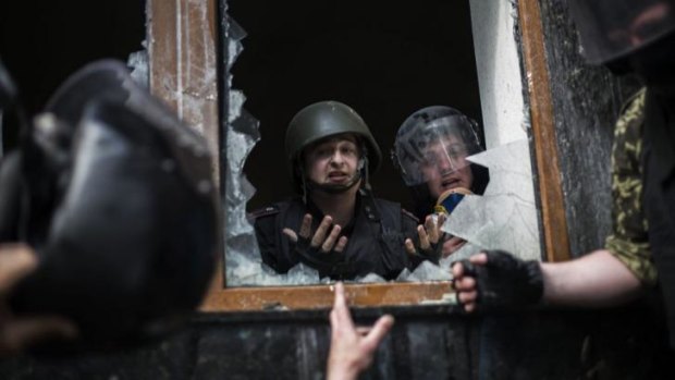 Ukraine police officers argue with a pro-Russian activist while the government building is taken.