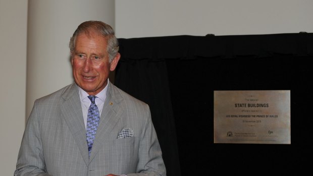 Prince Charles unveils a plaque as he tours the restored historical State Buildings.