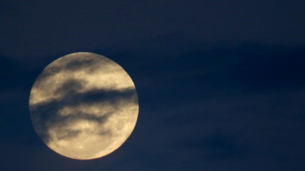 The supermoon peeks through the clouds over Sydney.