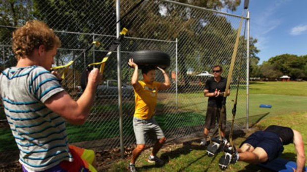 All part of the package ... Eddie Mendez, James Caskey and Brent Nassibian work out during a training session by Corporate Wellness Australia CEO Wayne Dart (second from right).