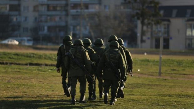 Russian soldiers march towards residential buildings near the Ukrainian marine military base at Perevalnoye in Crimea. Approximately 1000 Ukrainian marines are trapped inside the base.