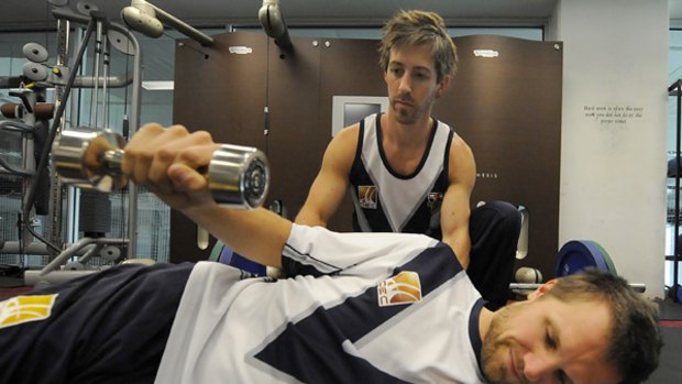 Victoria's strength and conditioning coach David Bailey watches Dirk Nannes go through his routine.