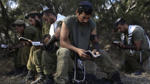 Israeli reserve soldiers pray after returning to Israel from the Gaza Strip on Monday.