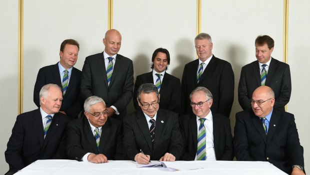 The brains trust: Bill Pulver and co. watch on as Tatsuzo Yabe of the JRFU signs on the dotted line.