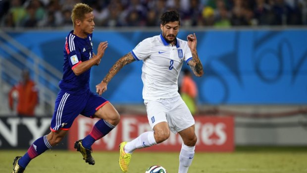 Japan's forward Keisuke Honda (left) vies with Greece's midfielder Panagiotis Kone (right) during their scoreless draw in Group C at the Dunas Arena in Natal.