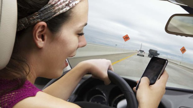 Driver distraction ... while it is illegal to drive and text, the Australian Mobile Telecommunications Association says hands-free mobiles used in cradles are legal.