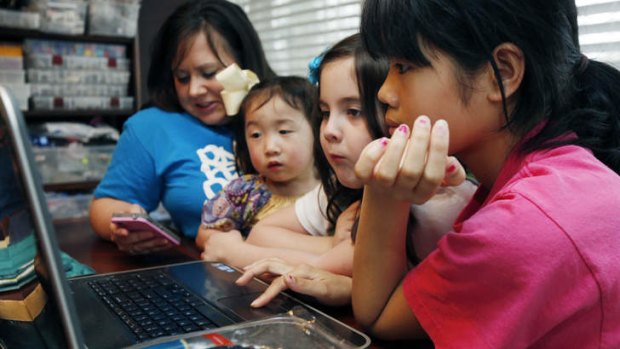 The Smith women, from left, mother Niki Smith, GiGi, 3, Macy Jade, 7 and Guan Ya, 14, use Google Translate on the family laptop to "speak" with their new daughter, Guan Ya.