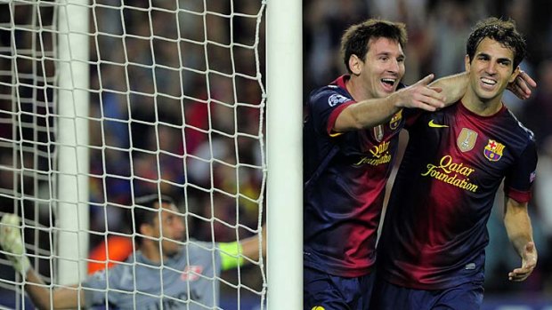 Lionel Messi is congratuled by midfielder Cesc Fabregas after scoring for Barcelona.