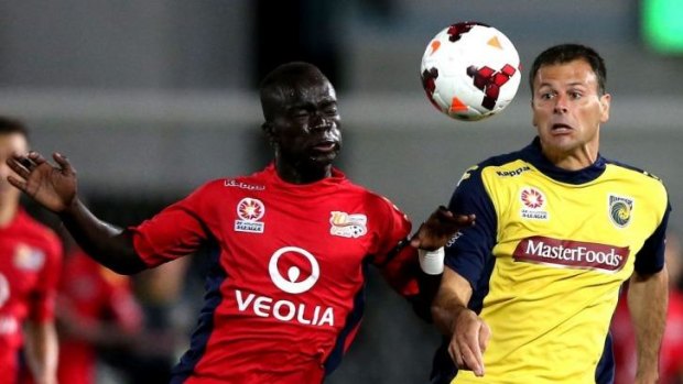 Clash: Adelaide United's Awer Mabil contests the ball against Mariners veteran Mile Sterjovski during the A-League elimination final at Central Coast Stadium.