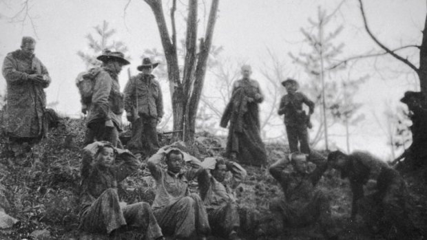 Soldiers from the 3rd Battalion, Royal Australian Regiment, watch over Chinese soldiers captured during the battle of Kapyong.