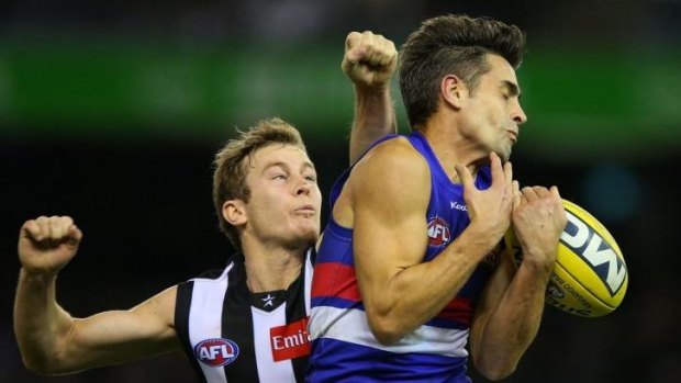 Daniel Giansiracusa of the Western Bulldogs attempts a mark ahead of Collingwood's Sam Dwyer.