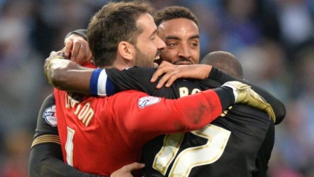 Wigan's goalkeeper Scott Carson celebrates with teammates at the final whistle.