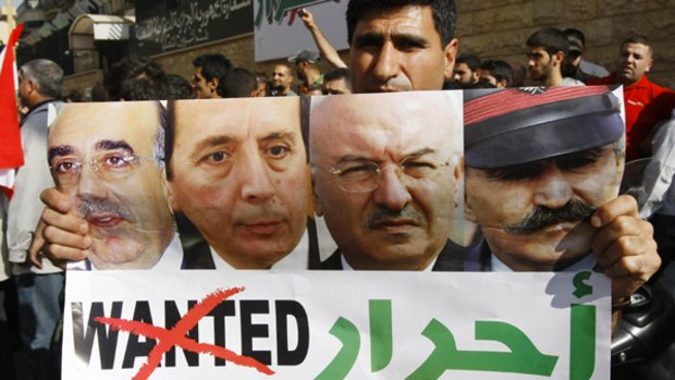 A supporter carries a poster with photos of the four released generals, with the word "wanted" replaced by "free".