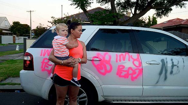 Residents in Challis Street awoke to find a trail of destruction left by teenage vandals. Katherine Clark, who is holding her friend's daughter Isabel, surveys the damage to her car.